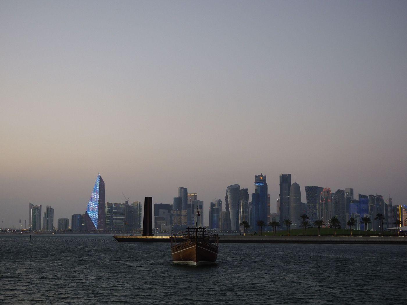 Gulf city waterfront and towers seen across calm coastal water